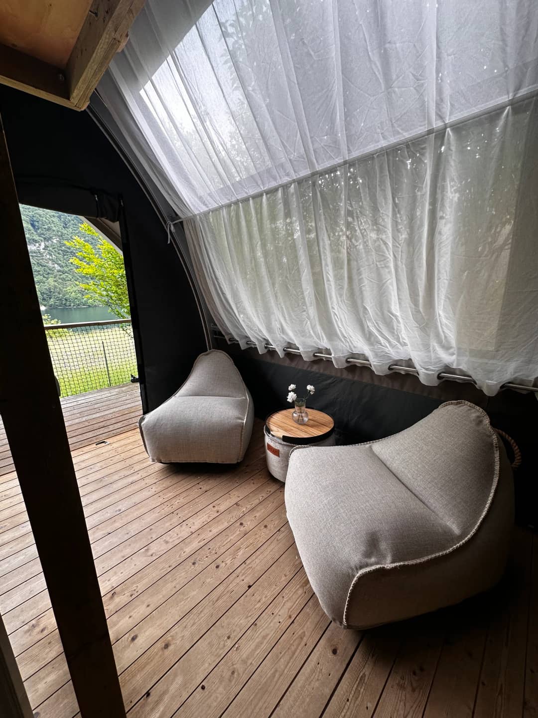 Seating area with pouffes beneath the light-coloured curtain in the Big Oak Lodge XS