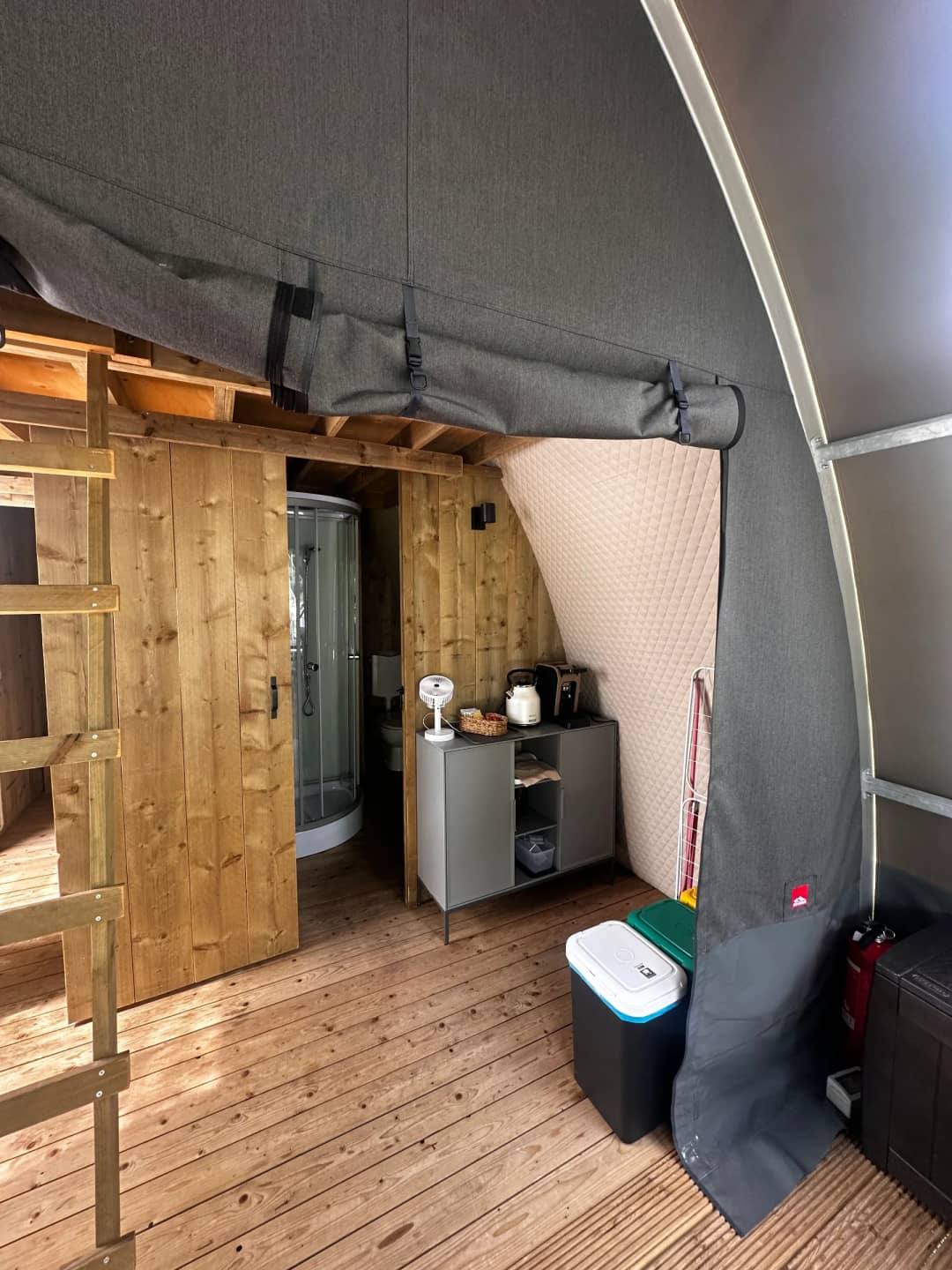 Inside the Big Oak Lodge XL: a wooden door leading to the shower cubicle and a cupboard containing a kettle and a toaster